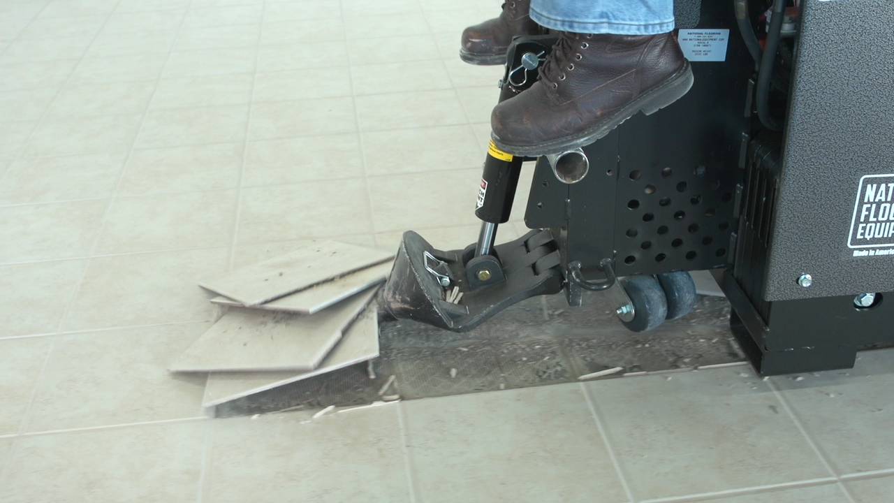 Ride-on scraper removing ceramic tiles.
